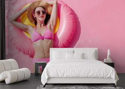 A woman in a pink bikini and straw hat laying on an inflatable raft Wall mural