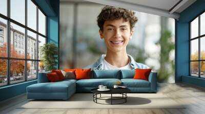 Closeup portrait of smiling smart curly haired school boy wearing braces on teeth looking at camera. Education concept  Wall mural