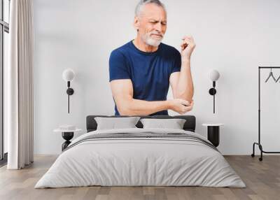 Middle age gray-haired bearded man suffering from pain in elbow on white background Wall mural