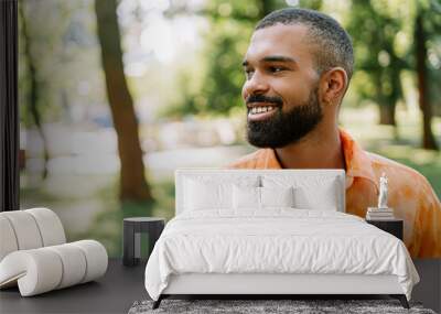 Portrait of african american young man outdoors looking away and smiling Wall mural