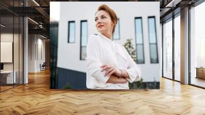 Portrait of confident middle aged businesswoman with arms crossed looking away outdoors   Wall mural