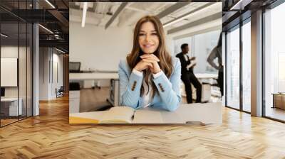 Smiling, beautiful woman in stylish suit, blue jacket working in modern office, looking at camera Wall mural