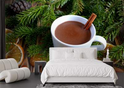 Hot chocolate or cocoa with cinnamon stick in a cup and fir branches. Winter hot drink for cold weather. New year and Christmas concept Wall mural