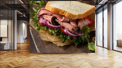 Roast beef sandwich with tomato, onion, lettuce and mustard sauce on dark background. Delicious healthy lunch with meat, hearty food Wall mural