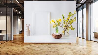 Home interior with easter decor. Mockup with a white frame and willow branches in a glass vase on a light background Wall mural