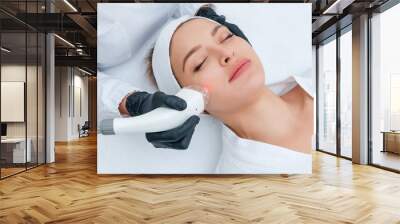 Young woman receiving laser treatment in cosmetology clinic Wall mural