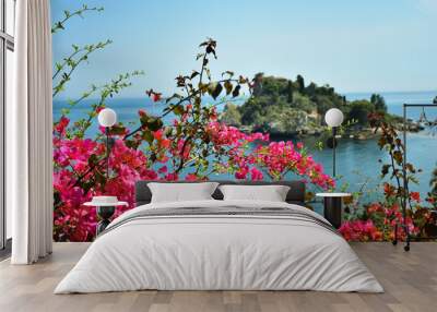 Beautiful island in taormina, surrounded by pink flowers and swallows. Isla bella en taormina, rodeada de flores rosas y golondrinas. Wall mural