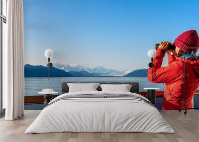 Alaska Glacier Bay cruise ship passenger looking at Alaskan mountains in binoculars exploring Glacier Bay National Park, USA. Woman on travel Inside Passage enjoying view. Vacation adventure banner Wall mural