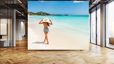 Antigua beach woman on cruise vacation travel in Caribbean island. Bikini girl walking on white sand wearing sun hat relaxing on idyllic paradise tourist attraction. Wall mural