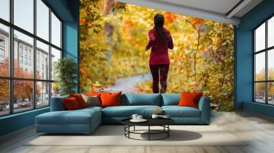 Autumn run active fit runner woman jogging in foliage forest woods of park, healthy living lifestyle exercising cardio in fresh air of outdoors. Wall mural