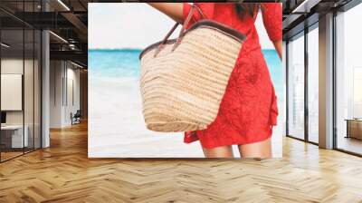 Beach bag vacation woman walking relaxing on tropical holidays holding tote purse for summer accessories for the beach. Tourist walking with red beachwear dress on travel holidays. Panorama crop. Wall mural