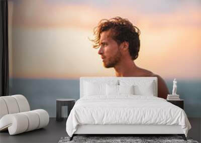 Beach body muscular man with six pack abs handsome good looking guy enjoying relaxing on summer Hawaii vacation sunset. Surfer lifestyle. Wall mural