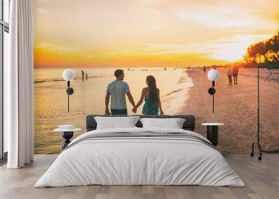 Beach summer beach people lifestyle happy couple enjoying sunset walk on Shelling beach famous tourist destination on the southwest coast of Florida -Gulf of Mexico. Sanibel Island, Florida. Wall mural