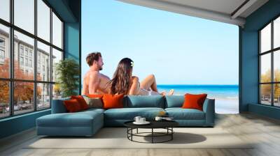 Beach vacation couple relaxing tanning in summer Wall mural