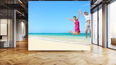 Beach vacation - happy fun tourists couple jumping Wall mural