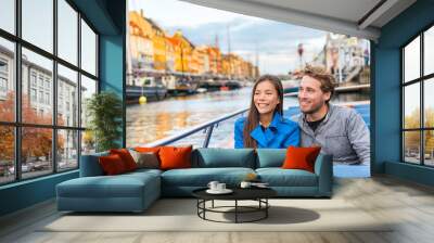 Copenhagen tourists people on Denmark travel holiday cruise boat tour in old port. Young multiracial couple travelers relaxing enjoying view of Nyhavn danish destination in Europe, fall or spring. Wall mural