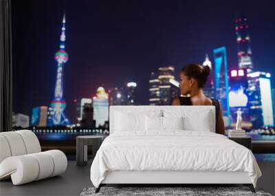 Elegant asian woman in evening dress relaxing by the Bund river in Shanghai looking at the night city lights of Pudong skyline. Luxury travel lifestyle. Wall mural