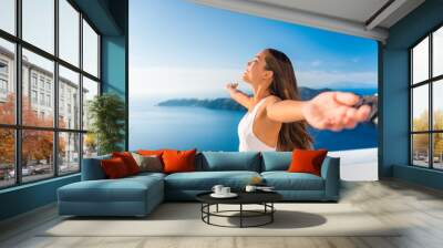 Europe cruise destination Santorini Greece travel vacation carefree woman enjoying freedom with open arms in famous travel holiday. Elegant Asian girl on greek travel luxury resort in Oia Santorini. Wall mural