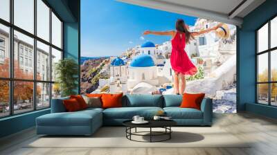 Europe travel vacation fun summer woman dancing in freedom with arms up happy in Oia, Santorini, Greece island. Carefree girl tourist in European destination wearing red fashion dress. Wall mural