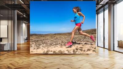 Fit woman athlete trail running in outdoor desert. Side view of Asian girl runner jogging outside. Fitness and sport active lifestyle in summer. Wall mural