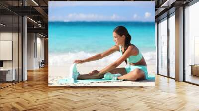 Fitness woman stretching legs on beach - Sporty Asian girl doing leg stretch Wall mural