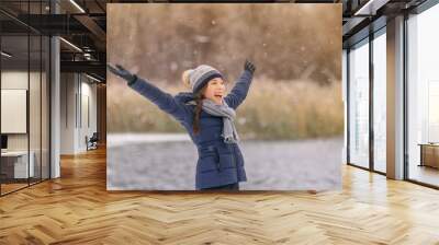 Happy winter snow fun Asian woman playing outside in snowfall enjoying falling snowflakes cold winter weather outdoors in nature forest healthy people lifestyle. Woman wearing hat, gloves ,coat. Wall mural