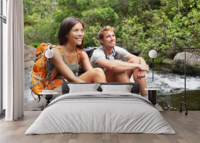 Hikers couple relaxing by river Wall mural