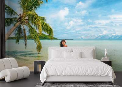 Luxury beach Tahiti Bora Bora bikini woman swimming in paradise getaway vacation. Beautiful Asian swimsuit model relaxing walking in turquoise ocean water in secluded island. Wall mural