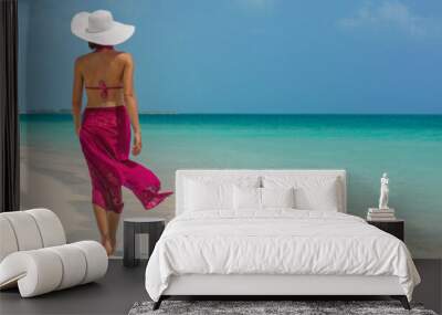 Luxury travel vacation elegant lady walking on beach in pink fashion skirt wrap relaxing on Caribbean holidays during winter. Panoramic banner landscape crop for background. Wall mural