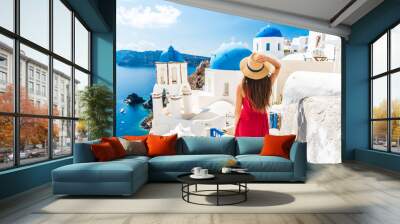 Luxury travel vacation Europe holiday Santorini girl in hat and red fashion dress walking 3 blue domes famous tourist attraction. Summer sun holidays adventure. Wall mural