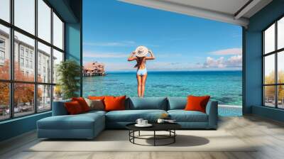 Luxury vacation hotel in Tahiti woman relaxing at infinity pool looking over ocean in French Polynesia travel summer holiday. Wall mural