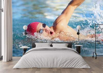 Man swimmer swimming crawl in blue water Wall mural