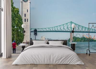 Montreal Old Port harbour woman walking on city street looking at view of St. Lawrence River with Jacques Cartier Bridge and Tour de l'Horloge on summer day. People tourist lifestyle. Wall mural