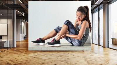 running injury leg accident- sport woman runner hurting holding painful sprained ankle in pain. fema Wall mural