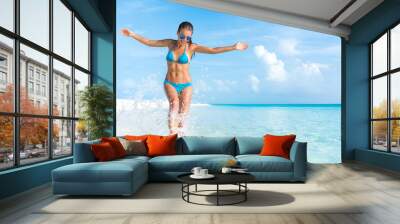 Sexy bikini body woman playful on paradise tropical beach having fun playing splashing water in freedom with open arms. Beautiful fit body girl on luxury travel vacation. Wall mural