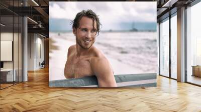 Sexy surfer surfing man with surfboard. Handsome young male athlete holding surf board with wet hair on summer beach sport holiday. Sports travel destination. Surfing lifestyle. Wall mural