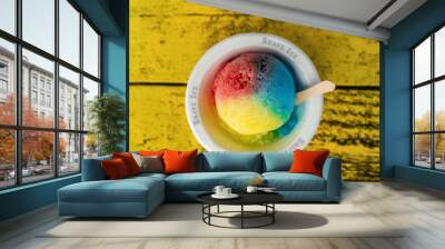 Shave Ice Hawaii local food hawaiian snow cone with three colors colored dyes. Frozen dessert food top view of bowl on retro yellow table. Wall mural