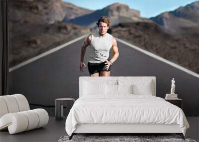 Sport athlete runner man running training endurance on mountain road sprinting fast towards camera. Sprinter exercising for marathon. Young male fitness model on run outdoor in banner landscape. Wall mural