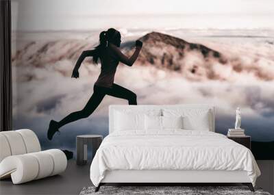 Trail runner athlete silhouette running in mountain summit background clouds and peaks background. Woman training outdoors active fit lifestyle. Wall mural