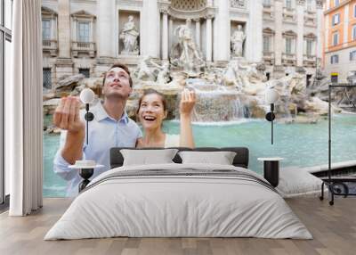 Travel couple trowing coin at Trevi Fountain, Rome Wall mural