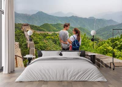 Travel tourists people sightseeing in China travel vacation. Happy interracial couple enjoying Great wall of China landscape near Beijing city. Asia travel summer holidays together. Wall mural