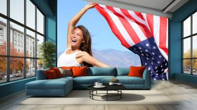 USA flag American woman waving the american flag in success. Asian girl cheering winner outdoors in summer banner panorama background. Beautiful energetic happy young model joyful excited. Wall mural