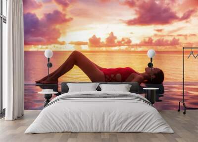 Vacation travel in paradise with sunset idyllic vacation woman silhouette relaxing in infinity swimming pool with beautiful colorful sky. Perfect amazing travel destination Wall mural