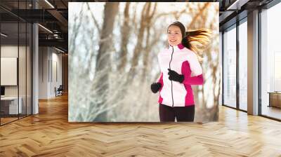 Winter run woman runner exercising in outdoor forest park. Asian athlete girl training cardio during cold season wearing gloves, warm headband for protecting the ears and jacket. Wall mural