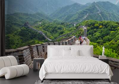 Woman backpacker student walking down the stairs overlooking the landscape of the Great Wall of china at famous Badaling tourist destination during travel vacation in Beijing. Asia summer holidays. Wall mural