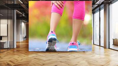 Woman running clutching calf muscle injury Wall mural