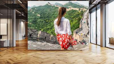 Young girl tourist from behind looking at view of Great Wall of china at famous Badaling tourism attraction during travel vacation in Beijing. Asia summer holidays. Wall mural