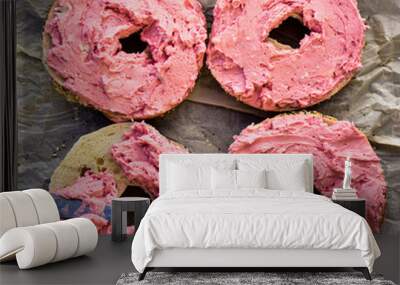 pink strawberry cream cheese spread onto sliced seeded bagel halves for bagel sandwiches Wall mural