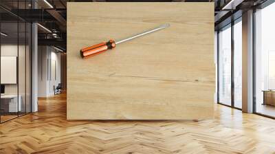 A screw driver isolated on a wooden background Wall mural