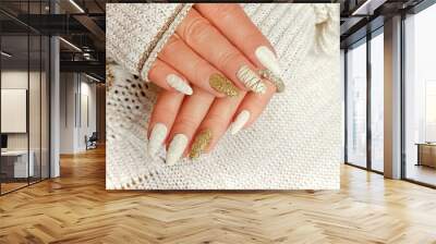 Knitted sand manicure on long oval nails with golden sequins and threads on the female red in a jacket. Winter trend in nail design. Wall mural